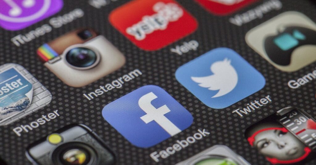 Close-up image of various social media app icons on a smartphone screen.